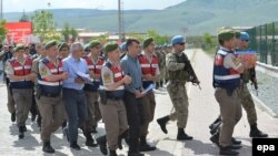 Turkish soldiers who are accused of participating in an attempted coup d'etat in 2016 are escorted to trial at a court inside Sincan prison in Ankara on May 22.