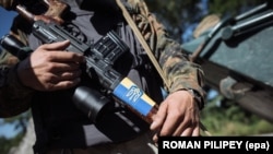 Український військовий зі зброєю, на якій наклеїний прапор з тризубом