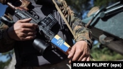 Ukraine – Ukrainian soldier holds a weapon with sticker of Ukrainian symbolic, Debalcevo, 5Sep2014