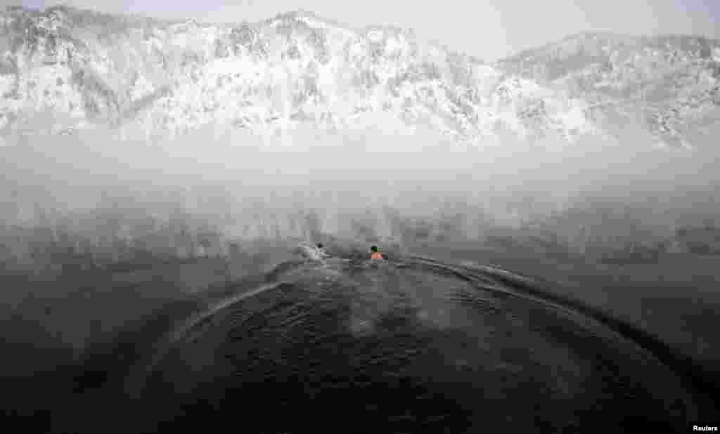 Members of a local winter swimming club bathe in the Yenisei River during their weekly bathing session, with temperatures at around minus-30 degrees Celsius, in the town of Divnogorsk, near Krasnoyarsk, Russia. (Reuters/Ilya Naymushin)