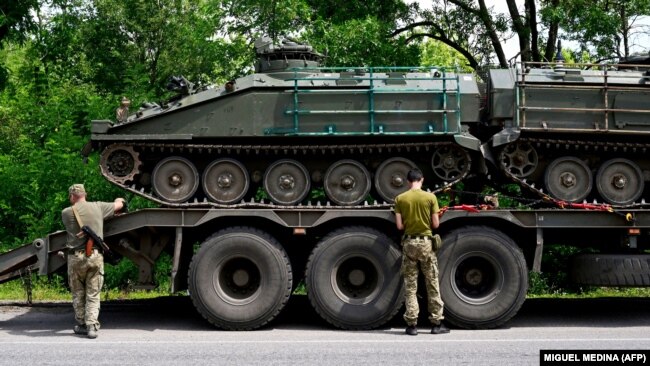 Украинские военные разгружают два британских бронетранспортера FV103 Spartan на востоке Украины. 9 июля 2022 года