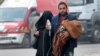 A man carries a child with an IV drip as he flees deeper into the remaining rebel-held areas of Aleppo on December 12.