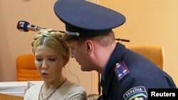 An Interior Ministry officer asks ex-Prime Minister Yulia Tymoshenko (left) to be quiet during a session at the Pechera district court in Kyiv in October 2011.