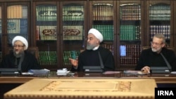Then-President Hassan Rouhani is seen flanked by ex-parliament speaker Ali Larijani (right) and his brother, then-judiciary chief Sadeq Larijani (left).