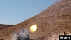 Anti-Qaddafi forces test fire a machine gun near the front line in the north of the besieged city of Bani Walid on September 11.