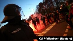 Rendőrök a járvány miatt elrendelt korlátozások elleni tüntetésen a németországi Lipcsében, 2020. november 7-én.