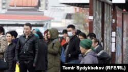 Бишкектин аялдамаларынын биринде автобус күтүп турган шаар тургундары.