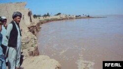 Afghanistan - Village elder Hadji Khaleq inspects the ruins of a home in Yaz Ariq Dinar destroyed by the advancing Amu Darya, undated