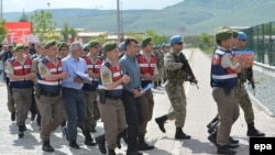 Turkish soldiers who are accused of participating in an attempted coup d'etat in 2016 are escorted to trial at a court inside Sincan prison in Ankara on May 22. 