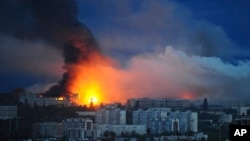 Fire and smoke rise from the site where a Russian missile struck a residential area in Kharkiv, Ukraine on June 7.