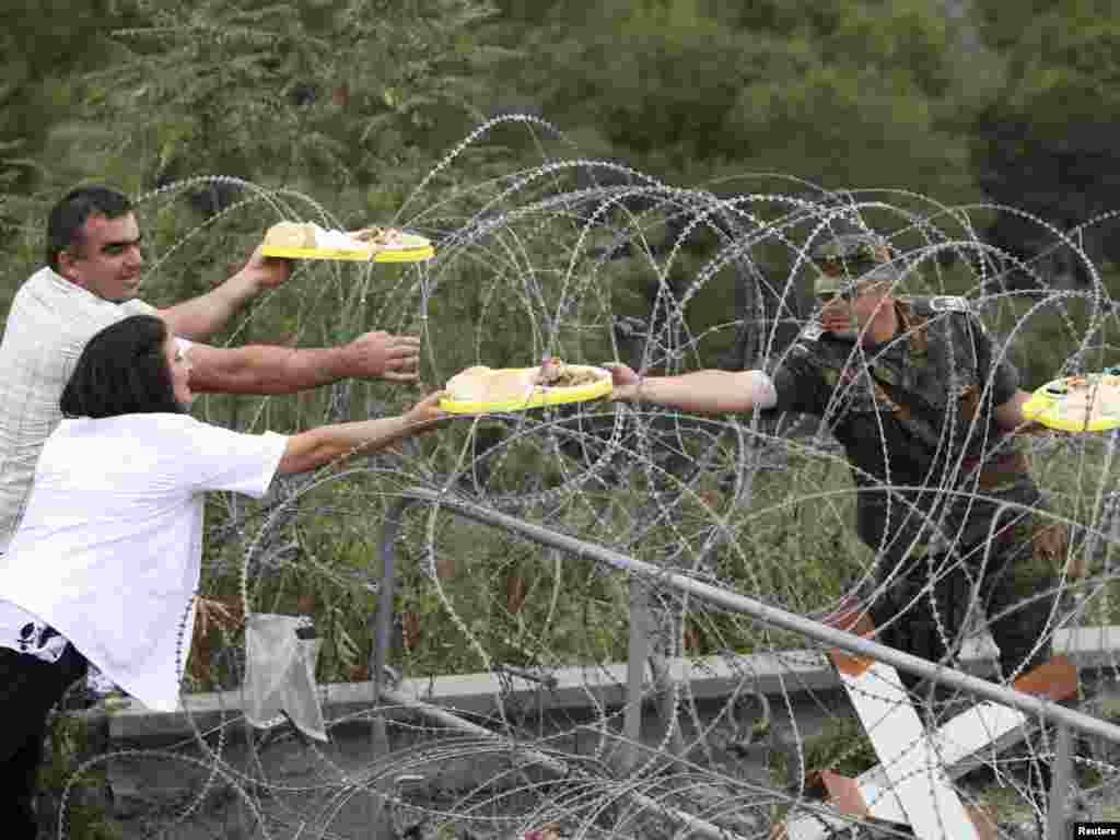 Lokalno srpsko stanovništvo nudi hranu njemačkim vojnicima KFOR-a na graničnom prijelazu Jarinje, 18.09.2011. Foto: Reuters 