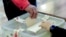 Armenia - A voter casts a ballot in a local election in Vagharshapat, November 16, 2025.