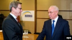 German acting Foreign Minister Guido Westerwelle (left) greets Ukrainian Prime Minister Mykola Azarov during the OSCE meeting in Kyiv on December 5.