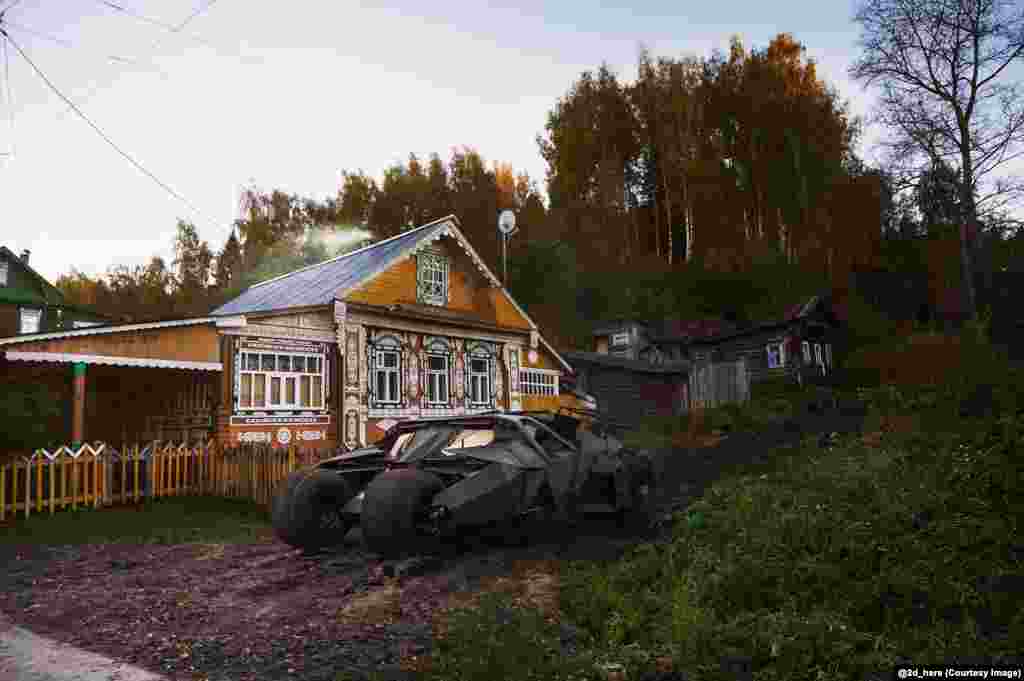 Batman's tumbler batmobile parked outside a dacha. 