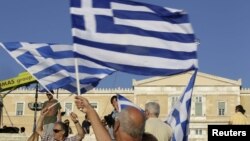 Greece -- A man holds a Greek flag before a conservative New Democracy party rally at Syntagma square in Athens, 15Jun2012