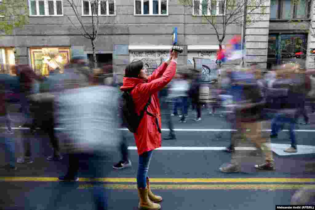 Женщина снимает демонстрантов во время антиправительственных протестов в Белграде, Сербия, 6 апреля 2019 года. (Aleksandar Anđić, RFE/RL)&nbsp;