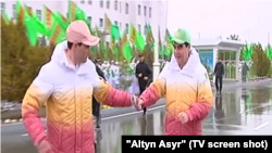 Turkmen President Gurbanguly Berdymukhammedov hands the baton to his son at a sporting event. (file photo) 