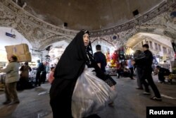 A woman walks with her purchases at the Grand Bazaar in central Tehran.