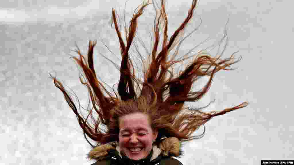 A woman reacts as her hair blows in the air on a windy day in San Sebastian, Spain. (epa-EFE/Juan Herrero)