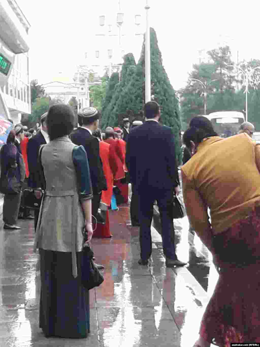 Aşgabat. Duralga. Ýagyşly howada awtobusa garaşýan ýaşaýjylar. Aprel, 2020.