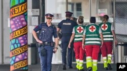 Un ofițer de poliție păzește intrarea în școala din Graz unde un fost elev a ucis 10 persoane și a rănit alte 12. 11 iunie 2025. 