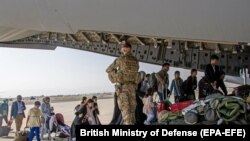گروهی از افغانها که به وسیله نیروهای بریتانوی از میدان هوایی کابل بیرون کشیده شدند