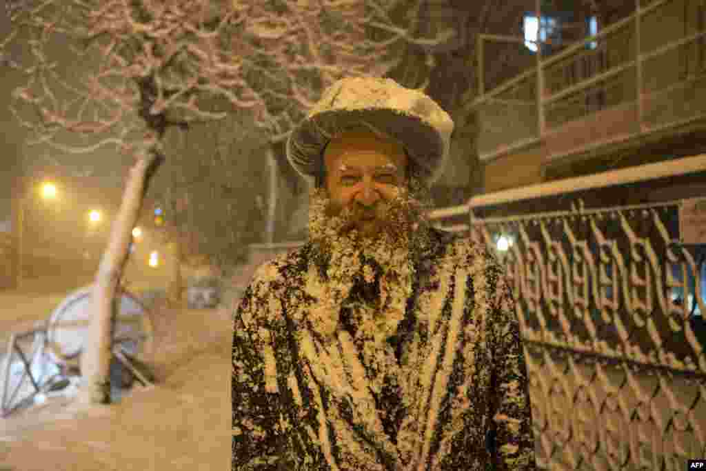 An ultra-Orthodox Jewish man covered with snow walks in Jerusalem. Jerusalem was transformed into a winter wonderland after heavy snowfall turned the Holy City and much of the region white, bringing hordes of excited children onto the streets. (AFP/Menahem Kahana)