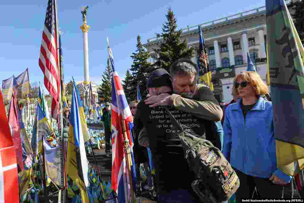 Attendees of the Kyiv ceremony embrace.In an Instagram post promoting the March 14 ceremony, Bill Cole wrote, "We will honor six Americans who gave their lives defending Ukraine and all of us. They are heroes."