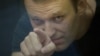 Russian opposition leader Aleksei Navalny gestures inside a glass-walled cage during his court hearing in Kirov on July 19