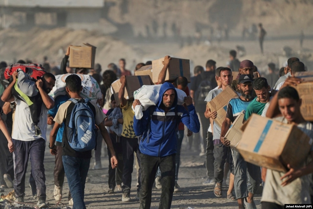Palestinezët duke bartur ndihmat që ua sollën kamionët.