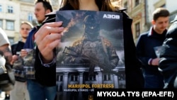 Ukrajinac s plakatom na skupu tražeći deblokiranje Mariupolja i spašavanje civila i njihovih branitelja, u centru Lviva, Ukrajina, 25. aprila 2022.