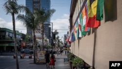 People walk past World Cup flags displayed on a building in Tijuana, Mexico, on May 23.
