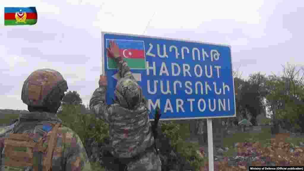 Азербайджанские солдаты крепят азербайджанский флаг на указателе в занятом ими селе Шюкюрбайли Джабраильського района, к 7 октября было под контролем карабахских сил. Фото опубликовано Министерством обороны Азербайджана