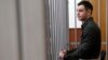 Trevor Reed stands inside a defendants' cage at a court hearing in Moscow in 2020. 