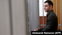 Trevor Reed stands inside a defendants' cage at a court hearing in Moscow in 2020. 