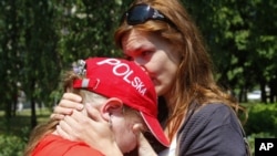 Aksana, wife of Andrzej Poczobut, comforts her daughter Yana as they stand in front of the court building where Paczobut is on trial in Hrodna.