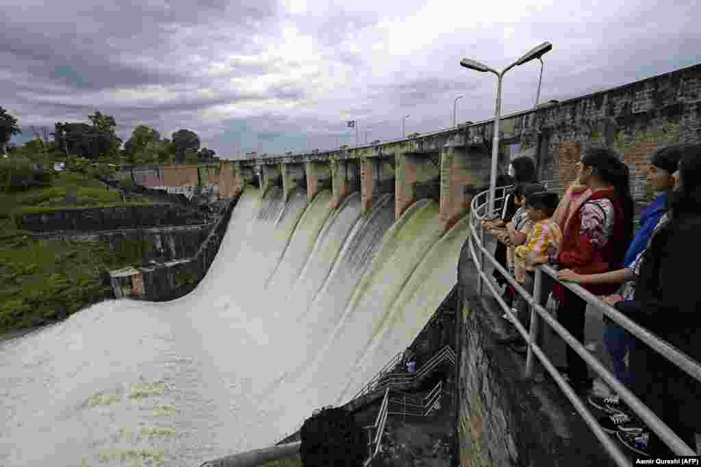 People watch at the Rawal Dam after the spillway opened due to heavy monsoon rains in Islamabad on August 31. More than 100 Pakistanis died in August because of the monsoon, which also destroyed more than 1,000 homes. (AFP/Aamir Qureshi)