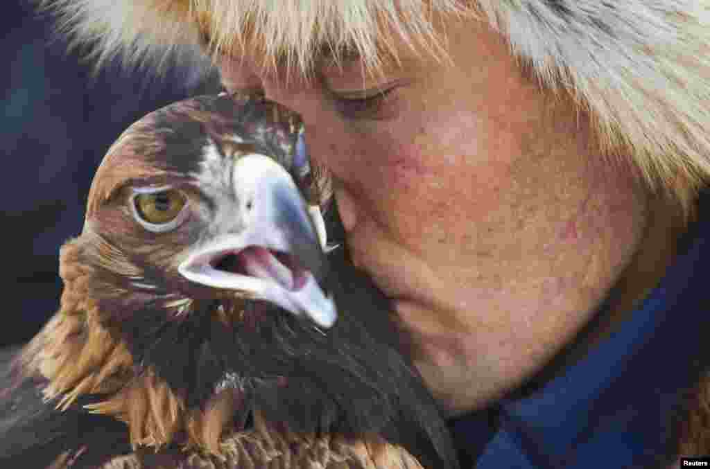 A Kazakh hunter whispers to his tamed golden eagle during an annual hunting competition in Chengelsy Gorge, some 150 kilometers east of Almaty. (Reuters/Shamil Zhumatov)