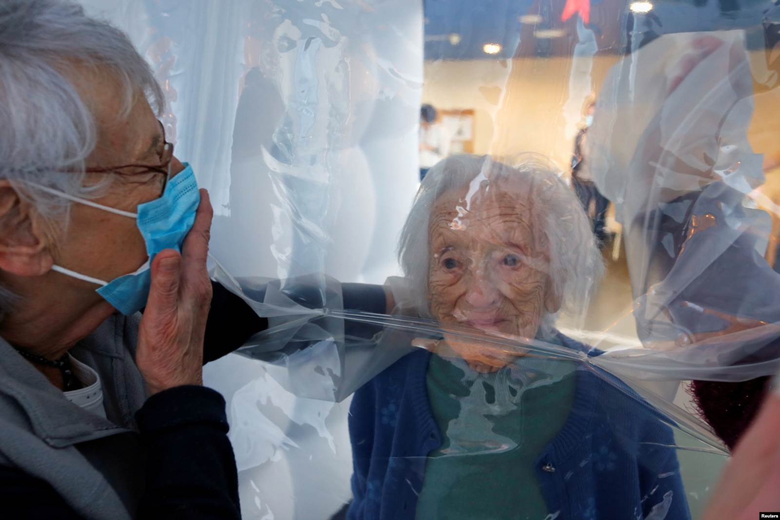 Djali i një 97-vjeçare duke biseduar me nënën, me një ndalesë plastike në mes.