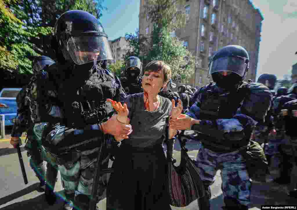 Муниципального депутата Александру Парушину задержали после того, как полицейские ударили ее по голове, 27 июля. Российская полиция задержала более 1300 человек в день протеста против предполагаемых нарушений на местных выборах. (Anton Sergienko, RFE/RL) Больше фото в этом фоторепортаже.