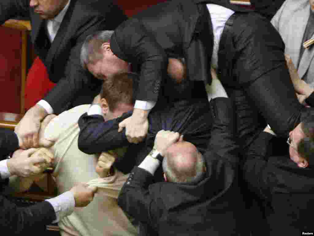 Ukrainian lawmakers brawl in parliament after the chamber approved a divisive deal allowing the Russian Navy to extend its stay on Ukrainian territory. Chaos erupted as opposition deputies threw eggs and smoke bombs. Photo by Gleb Garanich for Reuters