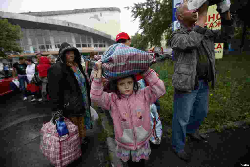 Residents of the Donetsk region in eastern Ukraine prepare to board buses for Rostov-on-Don in Russia from a collection point in the city of Donetsk on July 14. (Reuters/Maksim Zmeyev)