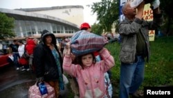 Residents of the Donetsk region in eastern Ukraine prepare to board buses for Rostov-on-Don in Russia from a collection point in the city of Donetsk on July 14.