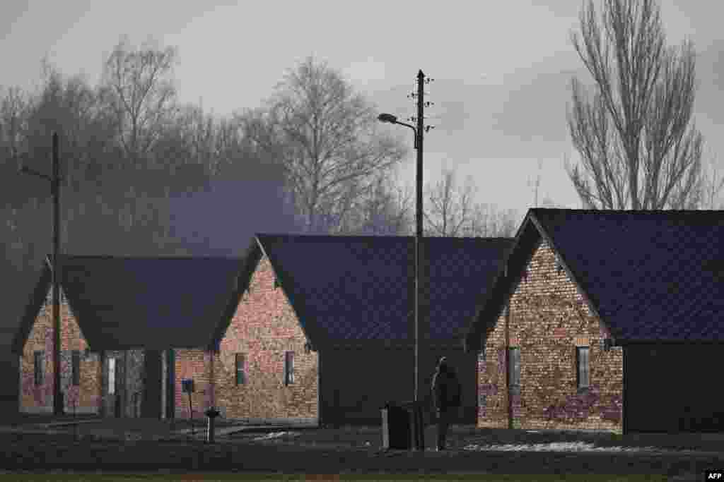 Un ofițer de securitate stă lângă baraca din fostul lagăr de concentrare și exterminare nazist german Auschwitz 2-Birkenau din Oswiecim, Polonia, pe 27 ianuarie 2025, înaintea comemorărilor care marchează cea de-a 80-a comemorare a eliberării lagărului de către Armata Roșie.&nbsp; &nbsp;
