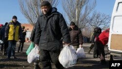 Жители села Широкино несут пакеты с гуманитарной помощью. 13 февраля 2015 года.