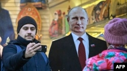 عکس یادگاری با تصویر مقوایی پوتین در مرکز شهر مسکو، نوامبر ۲۰۲۳