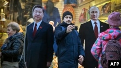 Figuri din carton ale președintelui Chinei, Xi Jinping, și președintelui rus, Vladimir Putin, pe strada Arbat din Moscova, 15 noiembrie 2023.