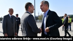 NATO Secretary-General Jens Stoltenberg (right) is greeted by Serbian Defense Minister Aleksandar Vulin in Belgrade on October 6. 