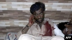 An injured Pakistani blast victim talks on a mobile phone at a local hospital after a bomb explosion at the shrine of 13th century Muslim Sufi saint Lal Shahbaz Qalandar in Pakistan on February 16. 