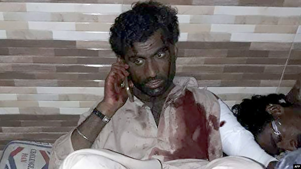 An injured Pakistani blast victim talks on a mobile phone at a local hospital after a bomb explosion at the shrine of 13th century Muslim Sufi saint Lal Shahbaz Qalandar in Pakistan on February 16.